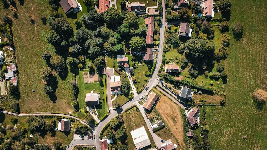 Houses with red roofs nestled among trees and winding roads.